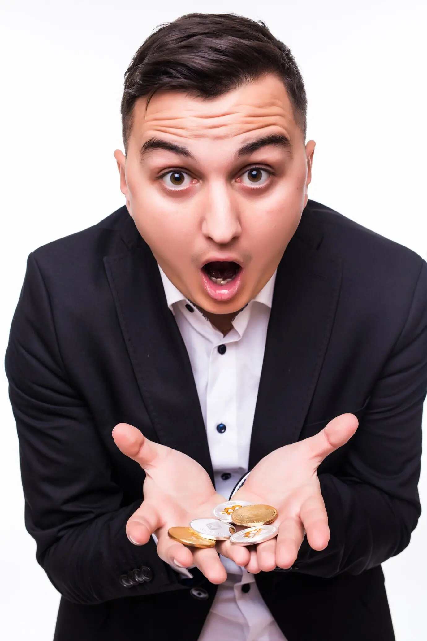 Un niño sostiene en sus manos distintas monedas cripto sobre fondo blanco.